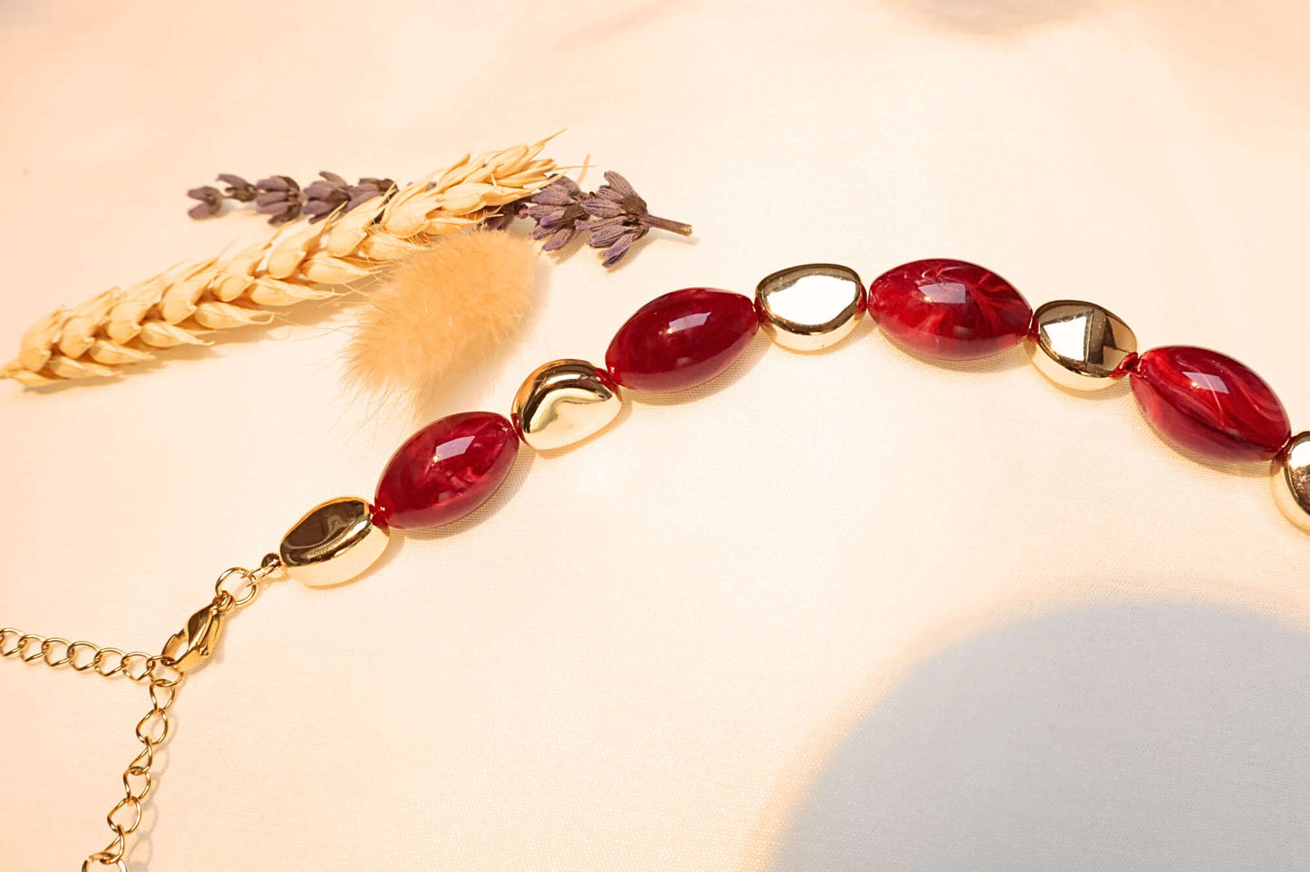 Handmade-look artistic necklace with red stone details.