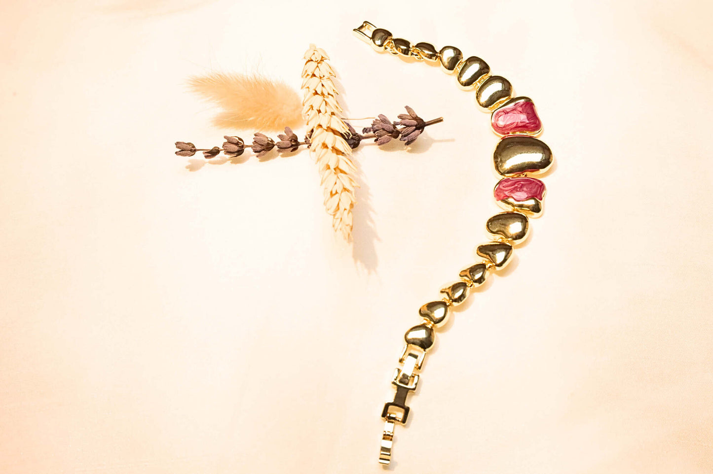 Gold-plated bracelet with heart motifs and red gemstones, a stunning piece to complement any elegant outfit.