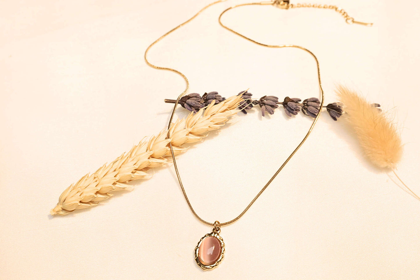 Gold snake chain featuring a vintage pink stone pendant.
