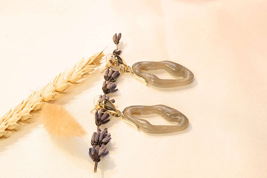 Elegant seashell-inspired earrings with a gold-tone finish, available in pearl white, black, and turquoise for a timeless look.