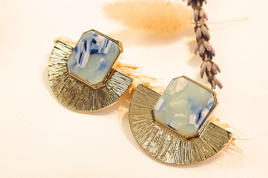 Elegant gold-plated earrings featuring a striking blue resin stone, ideal for chic outfits.