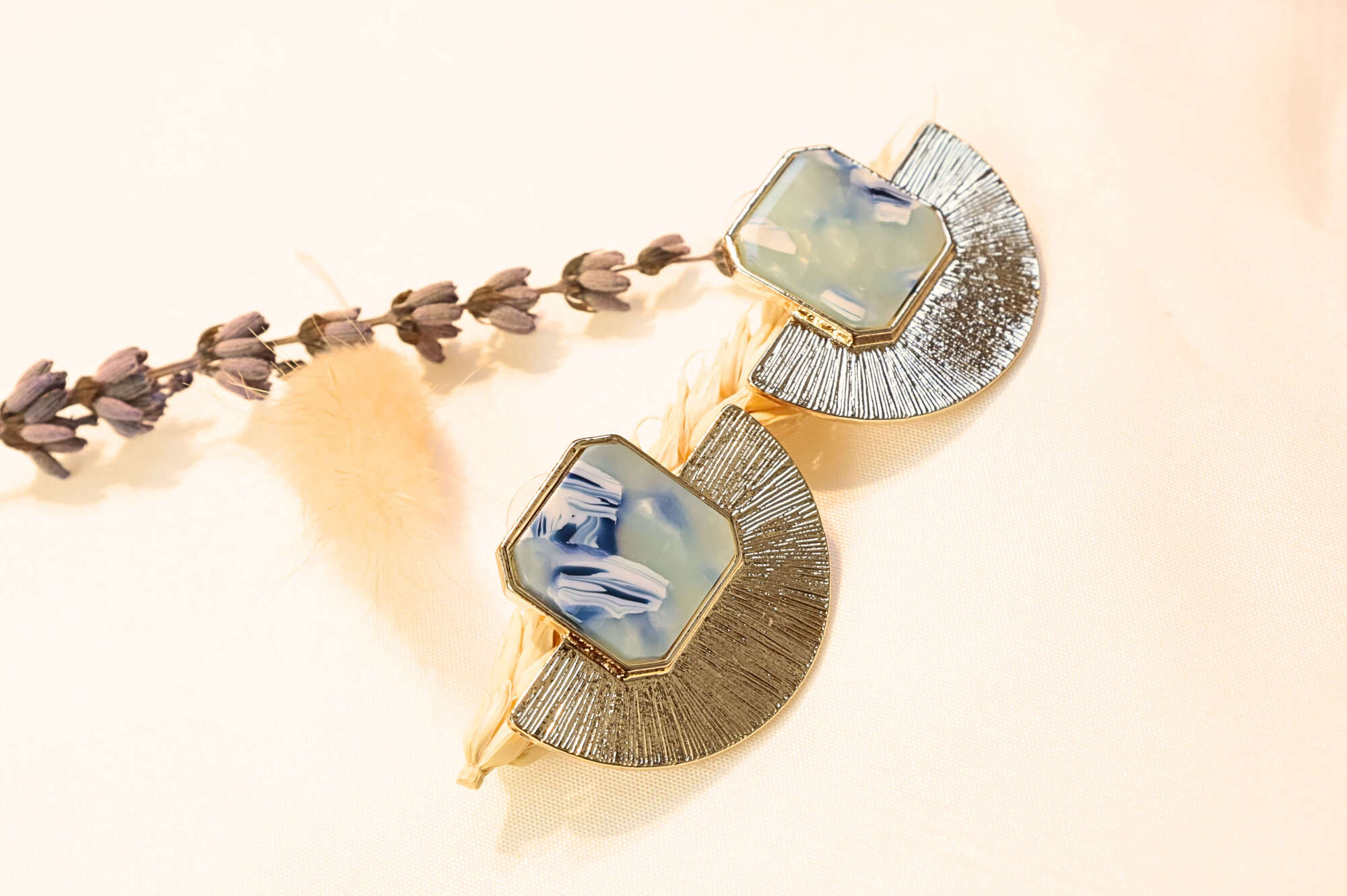 Chic gold-plated earrings with a mesmerizing blue resin stone, inspired by ocean waves and timeless elegance.