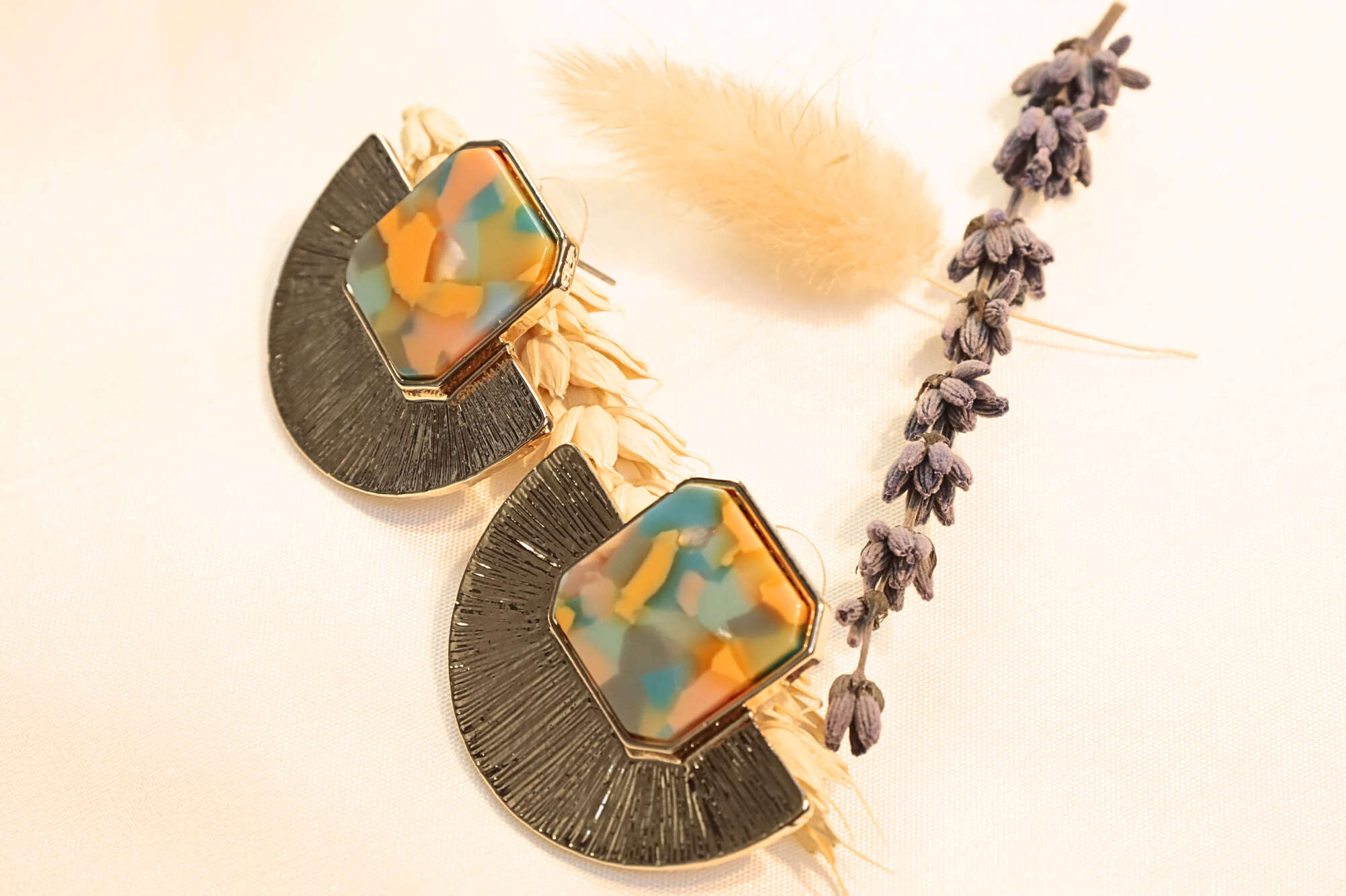 Bold and playful gold earrings featuring orange and multitone resin, a must-have for statement jewelry lovers.