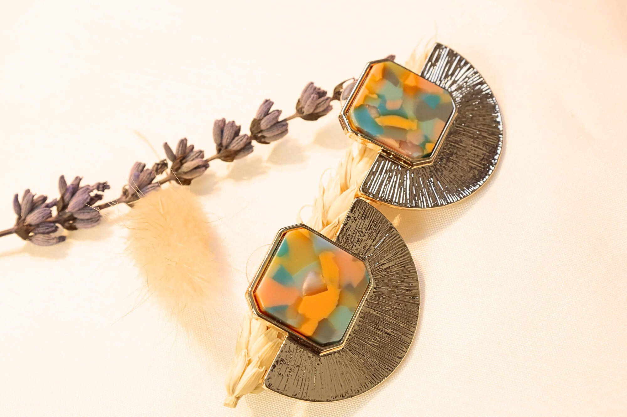 Gold-plated artistic earrings with a vibrant orange and multicolor resin stone, adding a unique touch.