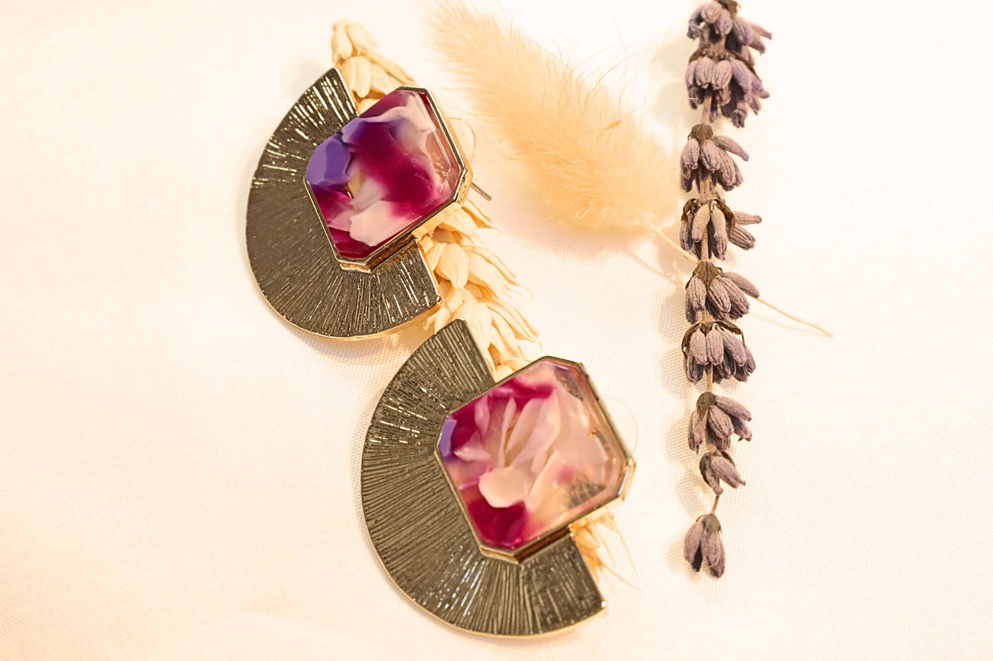 Gold-plated statement earrings with a bold red and pink resin stone, perfect for special occasions.