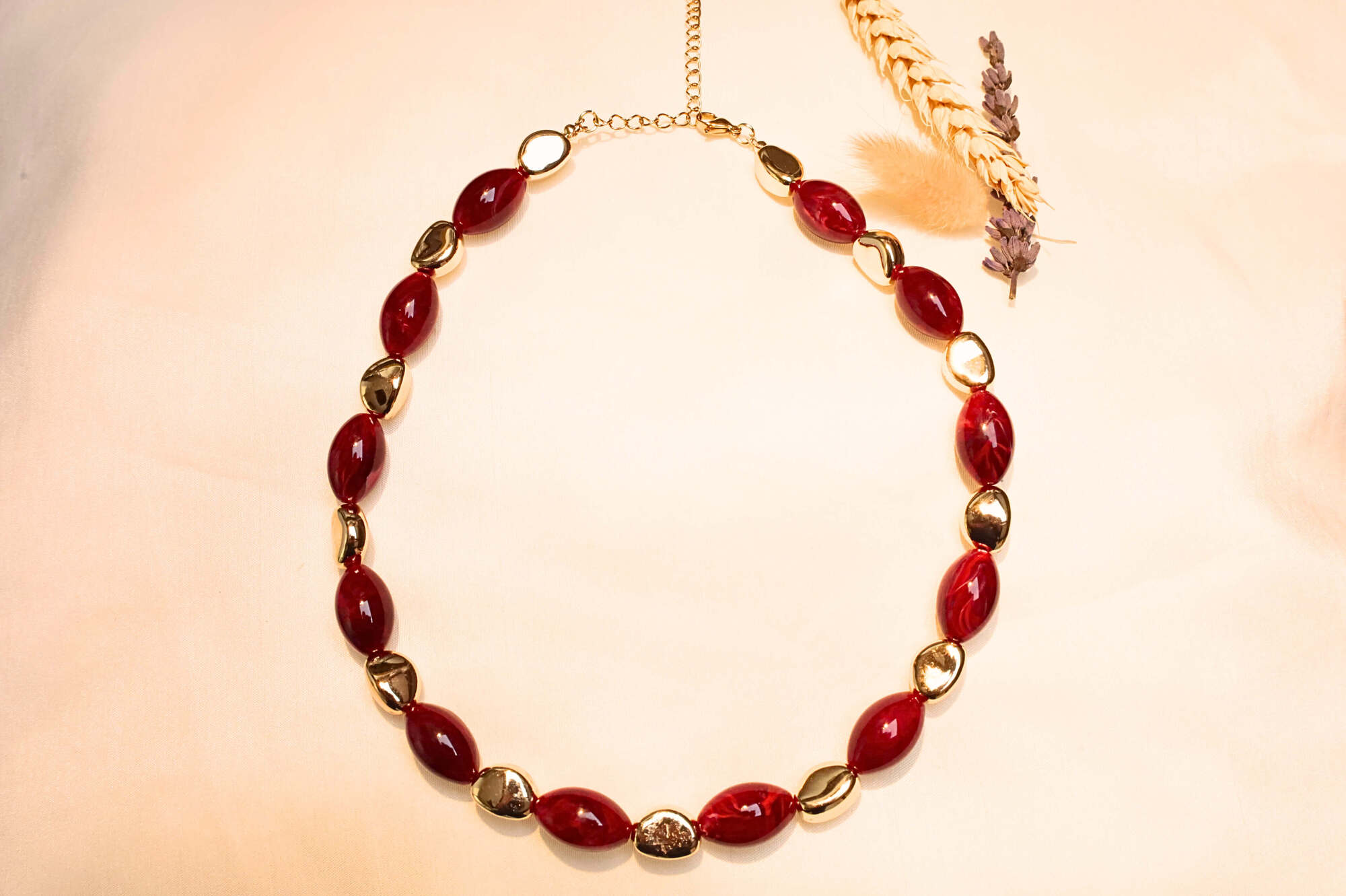 Bohemian-style gold-plated necklace with red stone effect.
