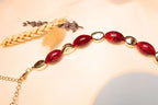 Handmade-look artistic necklace with red stone details.
