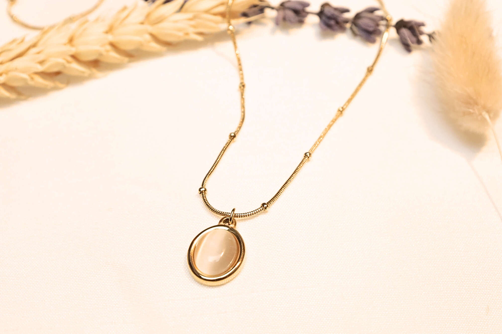 A delicate chain and oval stone pendant, complementing any outfit effortlessly.