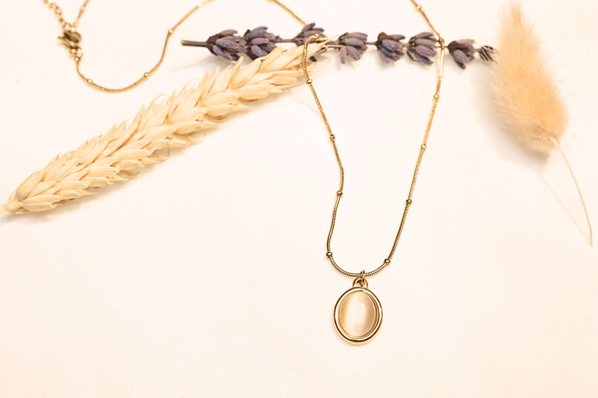 This gold-plated elegant necklace dazzles with its feminine details.