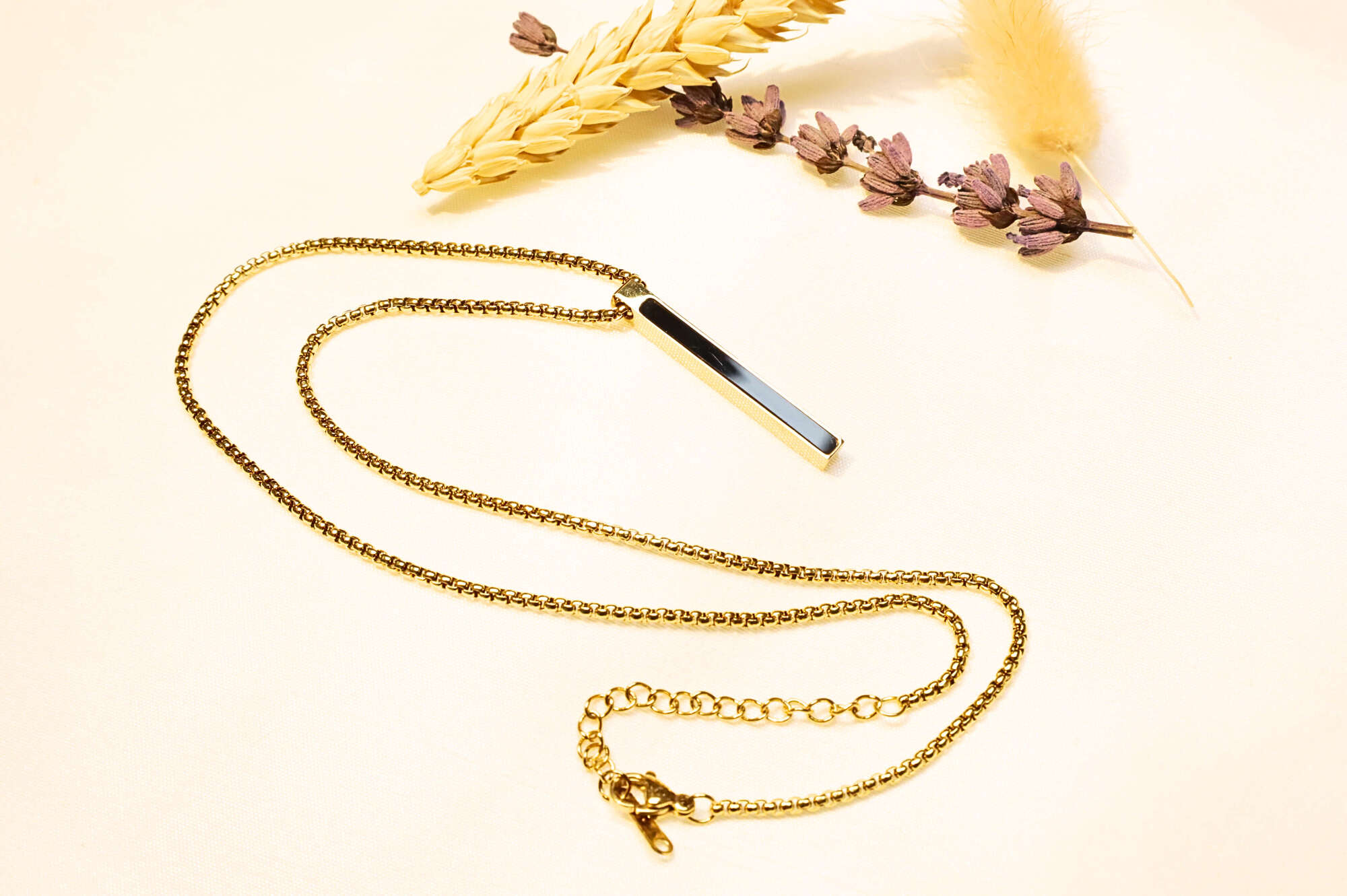 Minimalist gold necklace featuring a long rectangular pendant. A stylish unisex piece for any outfit.