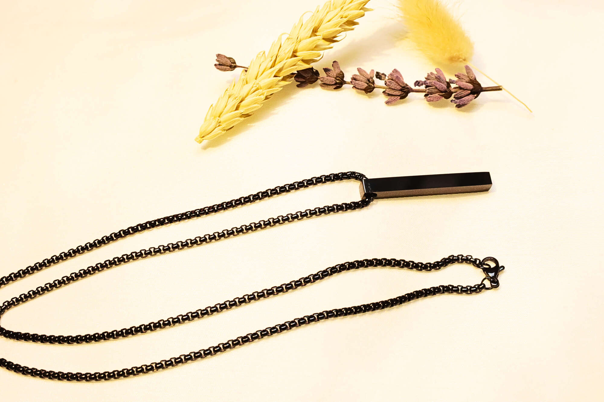 Bold black bar pendant necklace with a contemporary chain design. A statement piece for any wardrobe.