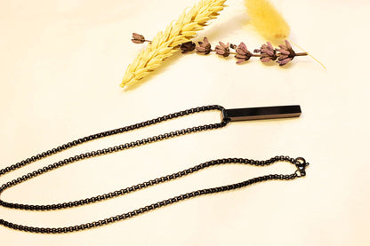 Bold black bar pendant necklace with a contemporary chain design. A statement piece for any wardrobe.