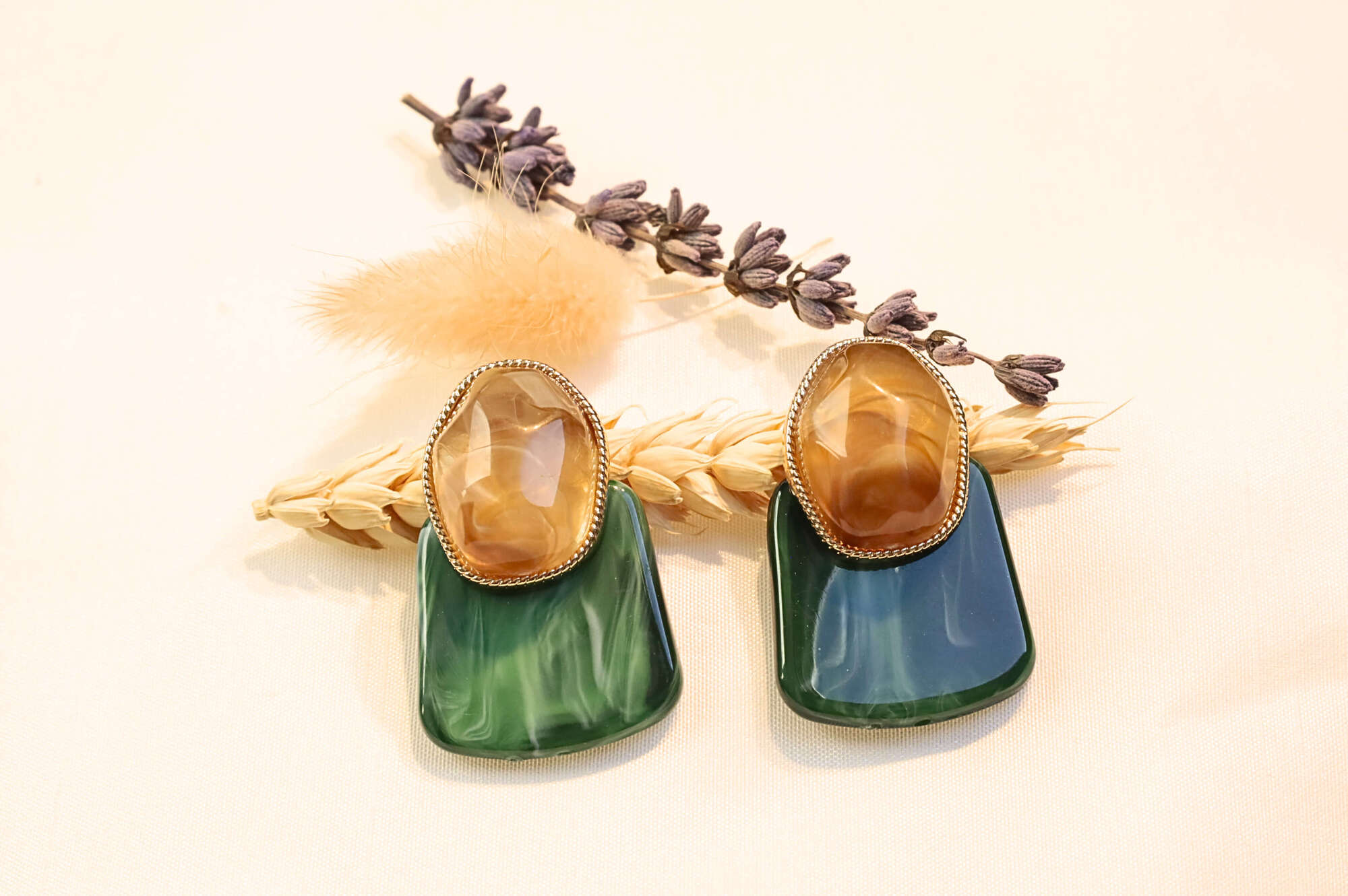 Elegant green statement earrings with a mix of natural stone textures.