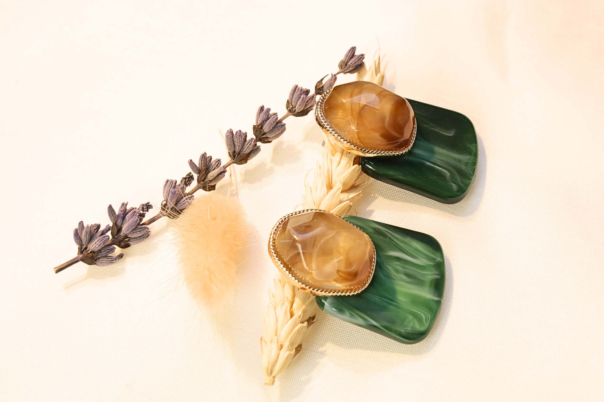 Bold and sophisticated green earrings featuring marbled resin and faceted stone.