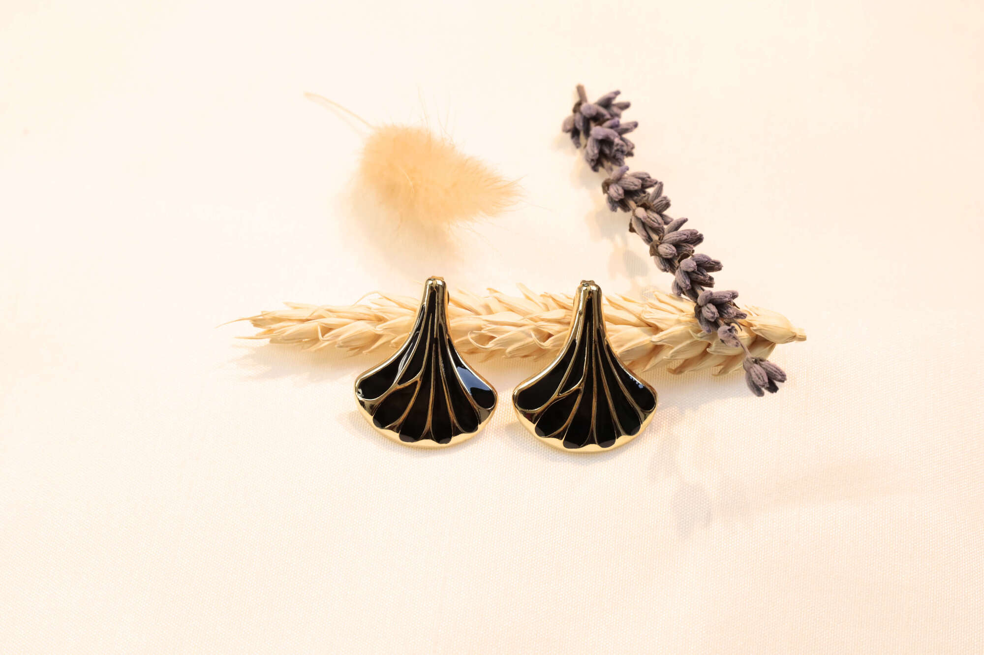 Elegant black seashell earrings displayed on fabric, radiating timeless charm and modern sophistication.