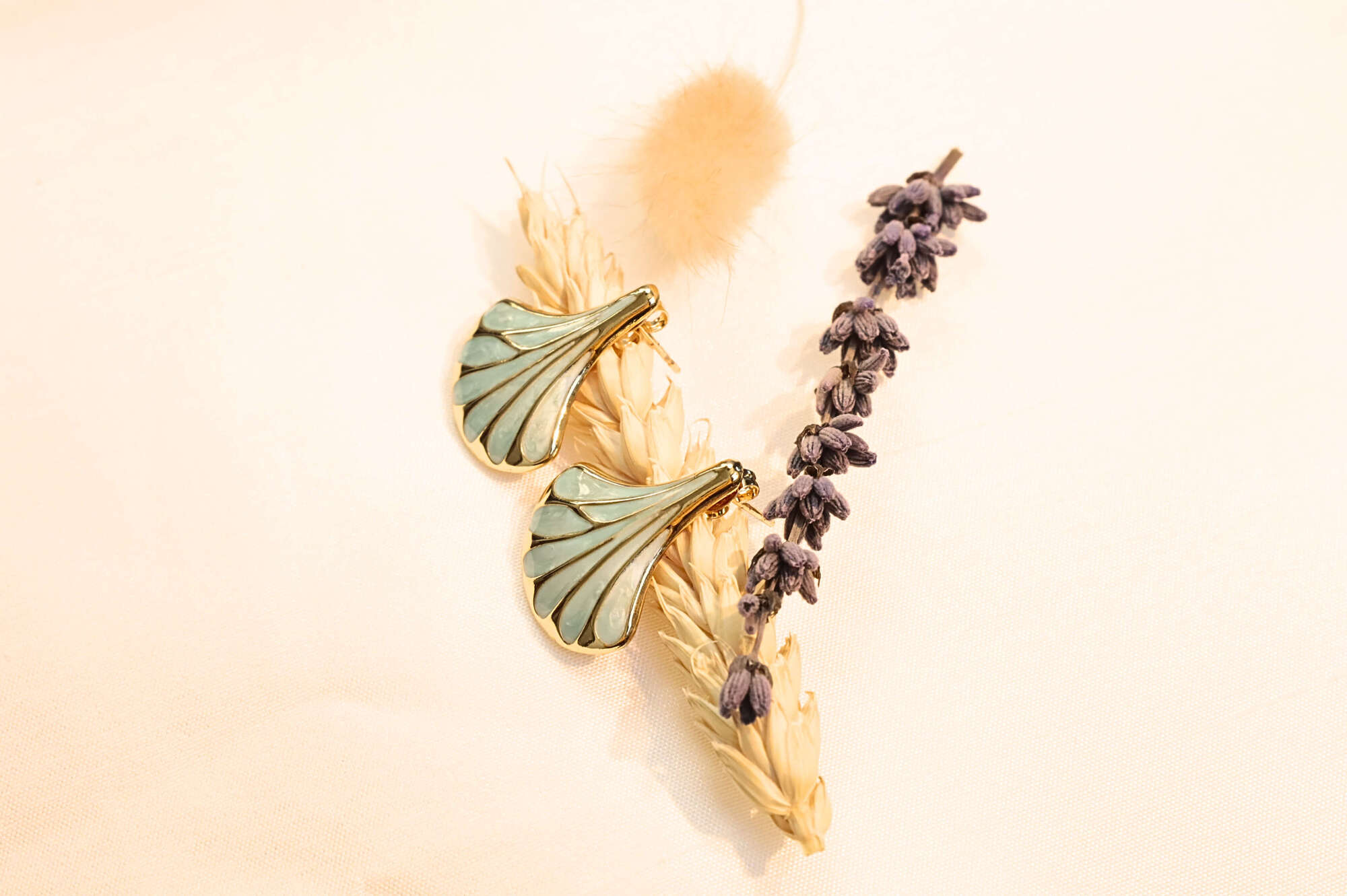 Turquoise seashell earrings with gold accents, reflecting oceanic elegance. A statement piece for any occasion.