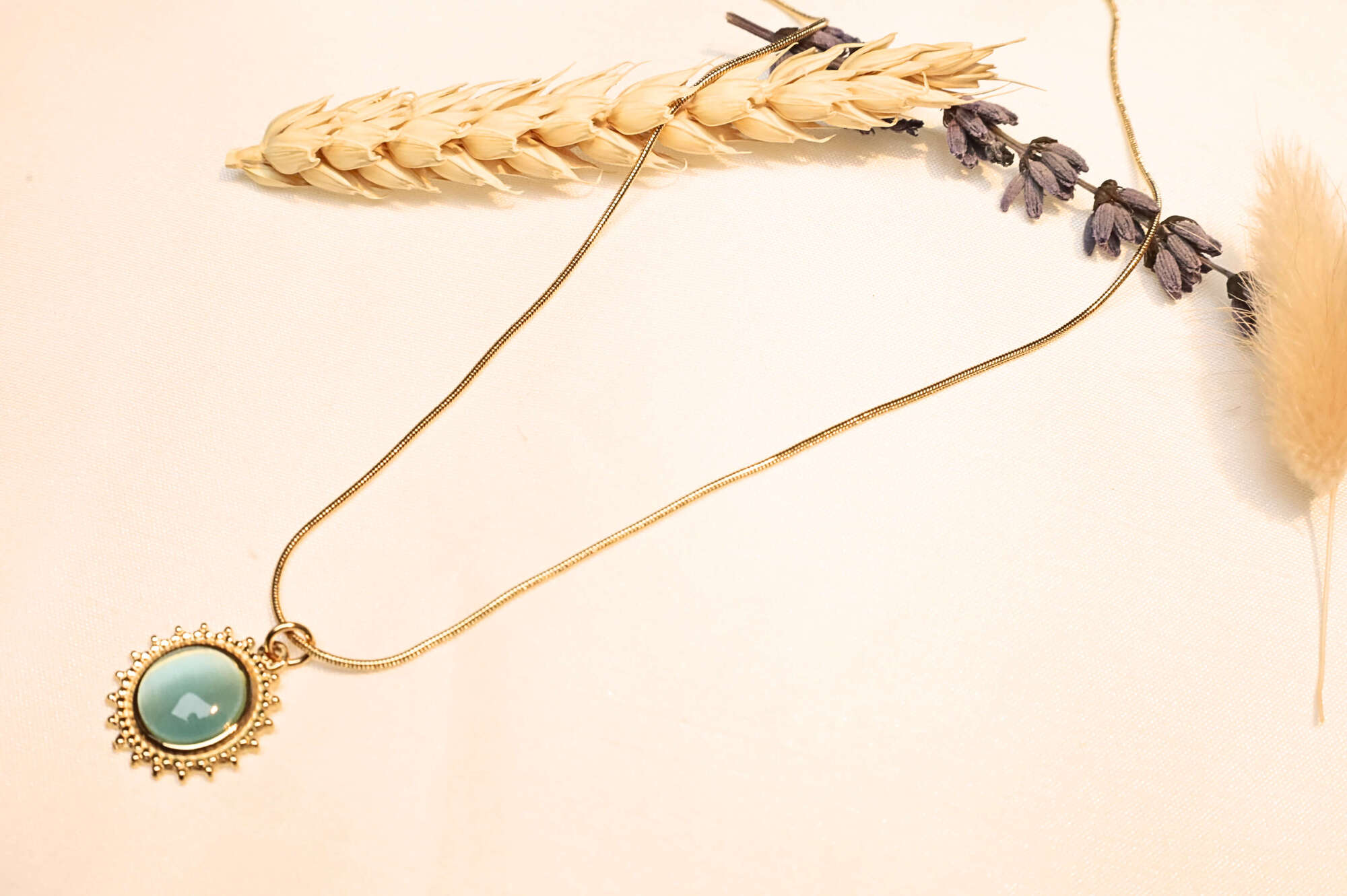 A close-up of the turquoise sun pendant, highlighting its intricate craftsmanship and lustrous finish.